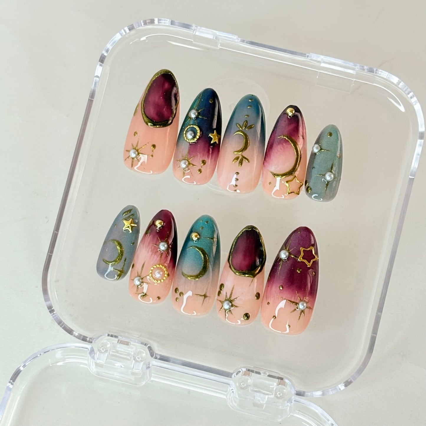 Cosmos Aura press-on nails flat-lay showing deep cosmic purple with stardust finish