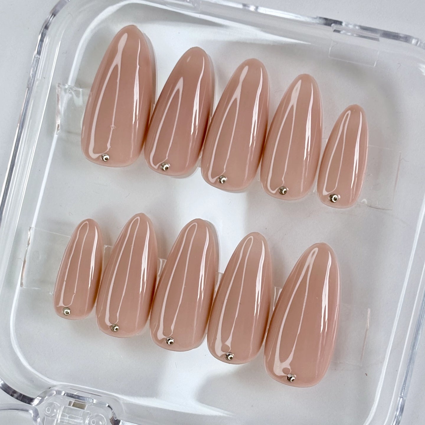 Dot of Grace press-on nails flat-lay showing nude base with minimalist dot pattern