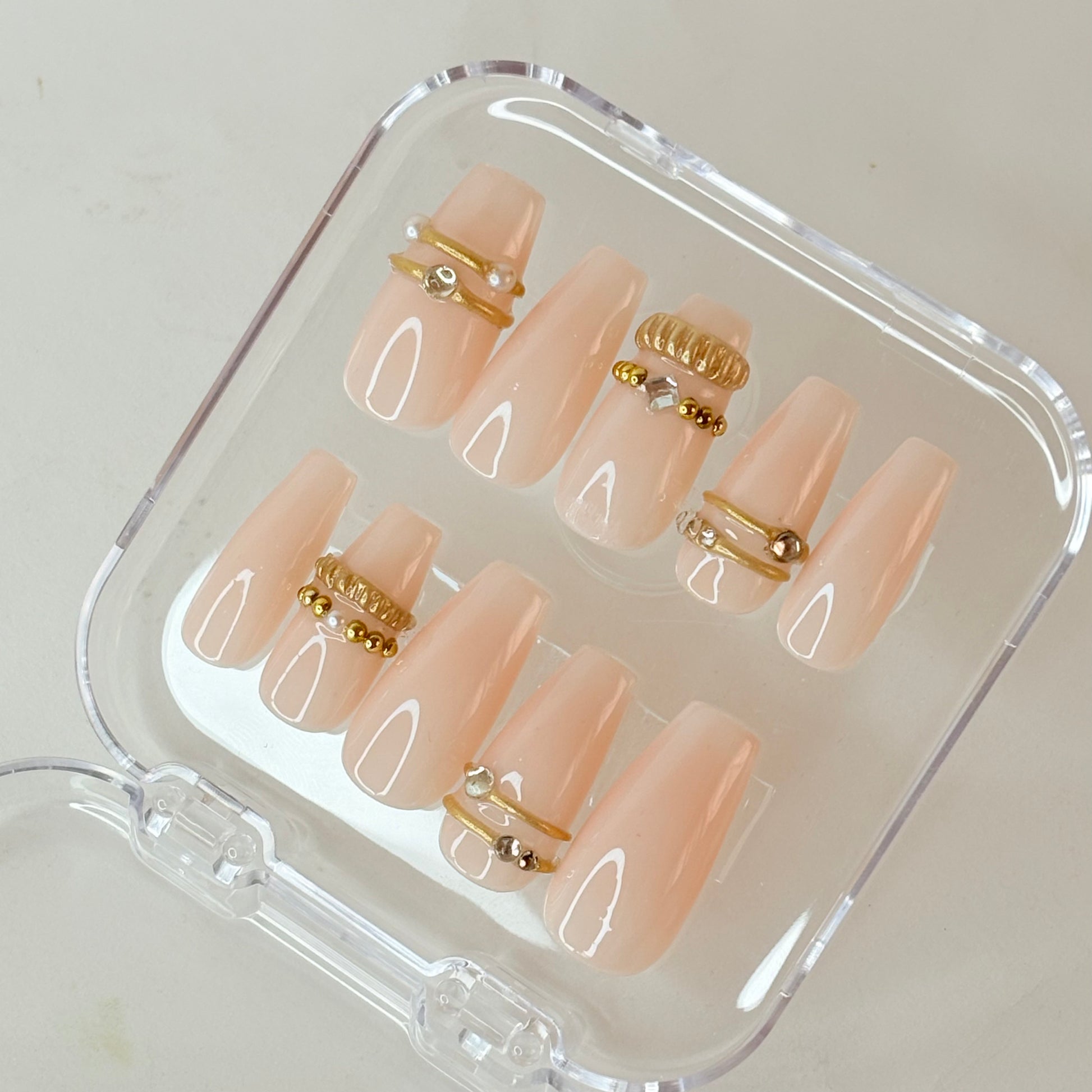 Crowned Glory press-on nails flat-lay showing gold crown art on ivory base