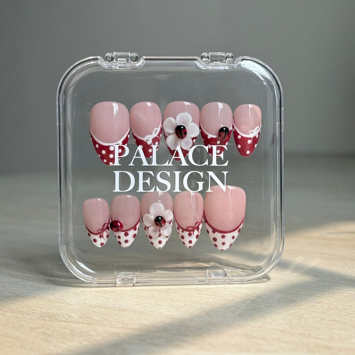 Ladybug Garden press-on nails worn on hand showing playful ladybug garden design
